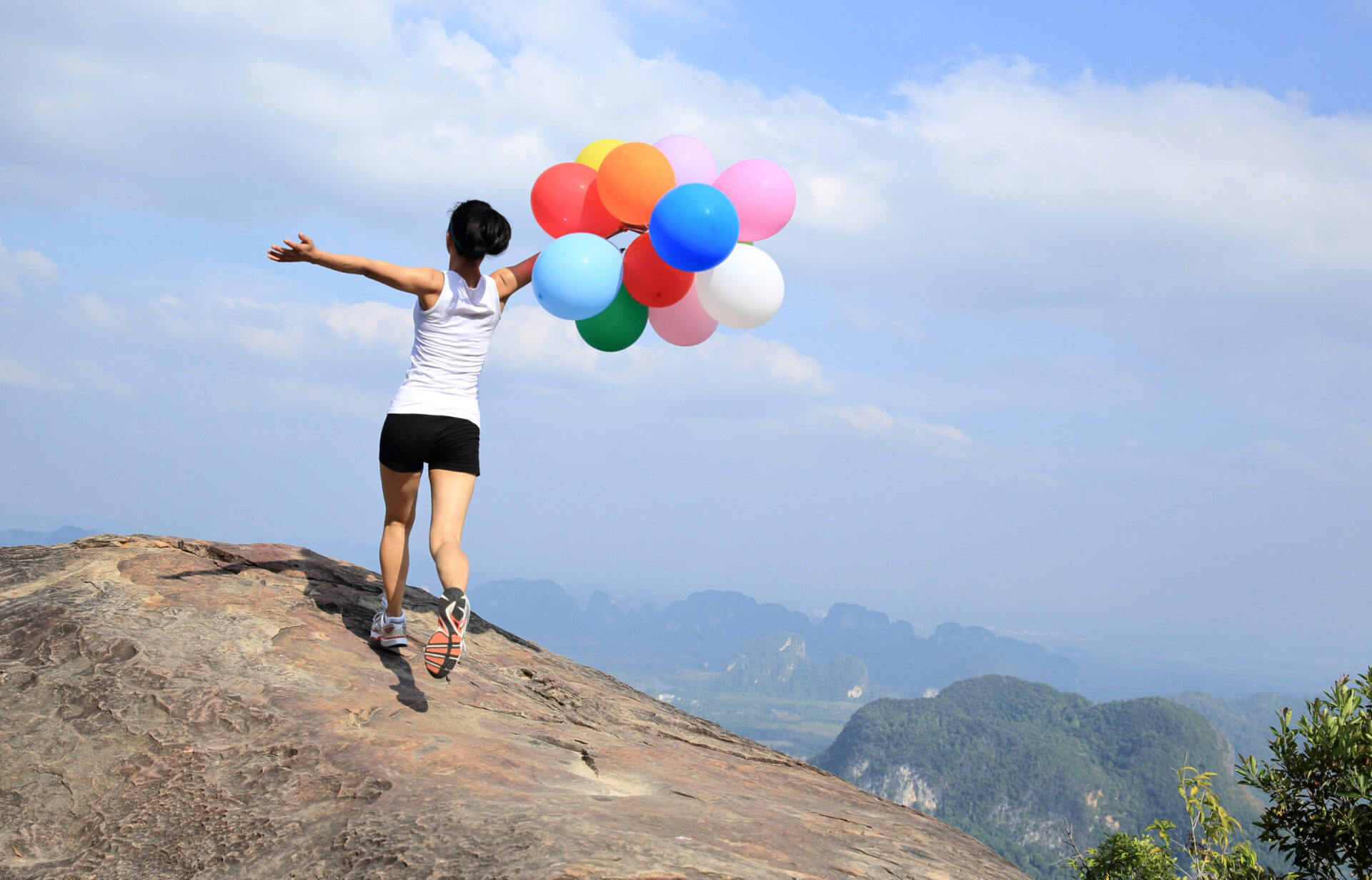Dame med ballonger i naturen